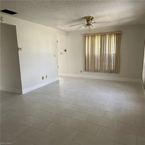 Unfurnished room featuring ceiling fan and a textured ceiling