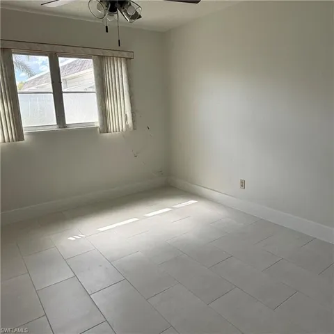 Empty room featuring ceiling fan and a textured ceiling