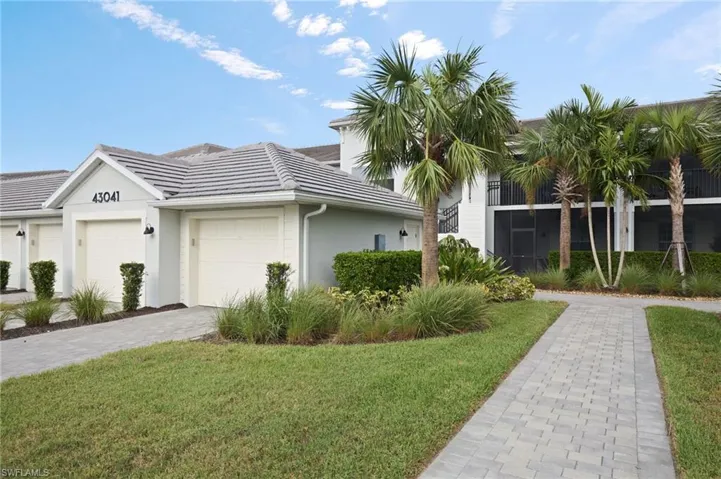 View of front of Condo with a garage and a front lawn