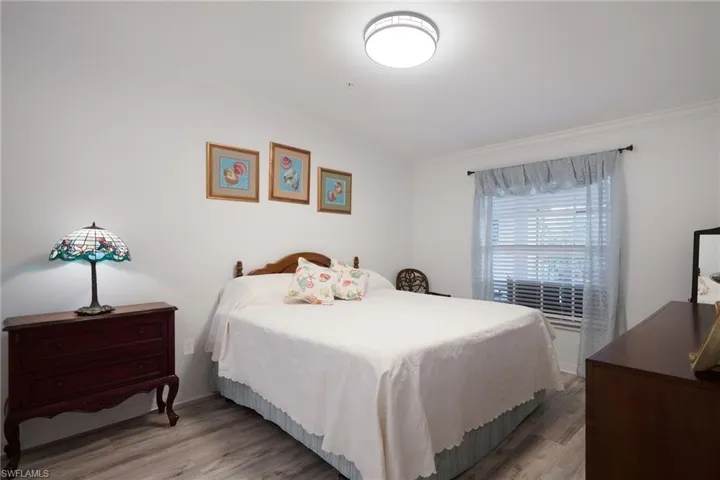 Bedroom with ornamental molding and light hardwood / wood-style flooring