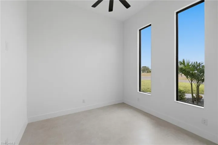 Unfurnished room featuring baseboards and ceiling fan