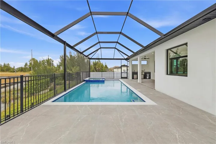 View of swimming pool with a sunroom, a patio, a pool with connected hot tub, and glass enclosure