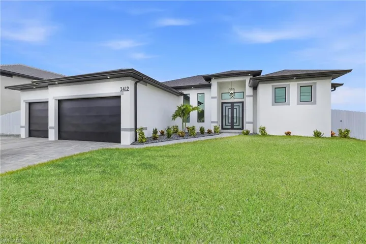 Prairie-style home featuring an attached garage, decorative driveway, and stucco siding