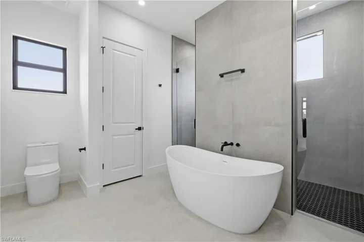 Full bathroom with a shower stall, a freestanding bath, and recessed lighting
