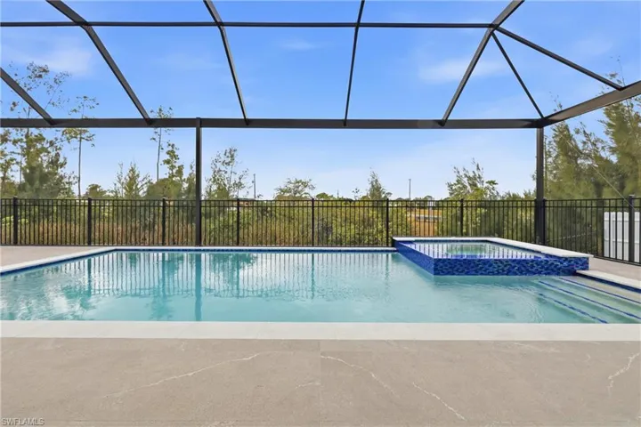 View of pool featuring a lanai, a pool with connected hot tub, a sunroom, and a patio