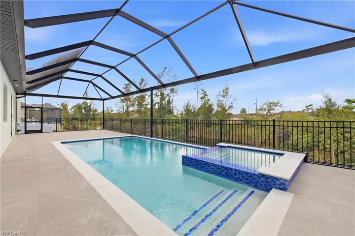 View of swimming pool with a sunroom, a pool with connected hot tub, a patio area, and a lanai