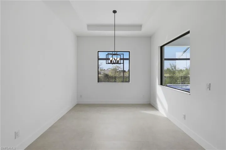 Unfurnished dining area with a tray ceiling and a chandelier