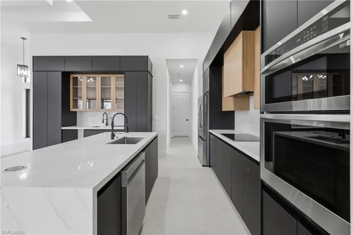 Kitchen featuring appliances with stainless steel finishes, dark cabinets, modern cabinets, and recessed lighting