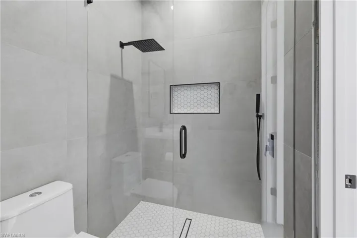 Full bath featuring a stall shower and toilet
