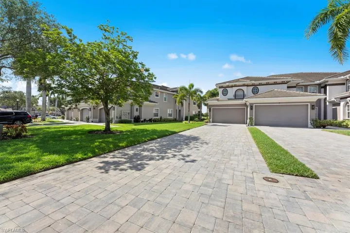 Mediterranean / spanish-style house with decorative driveway, a front lawn, stucco siding, and a residential view