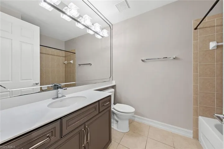 Bathroom with vanity, tile patterned flooring, and shower / bathtub combination