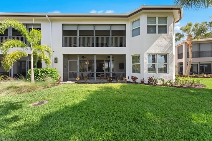 Back of property featuring stucco siding, a yard, and a ceiling fan