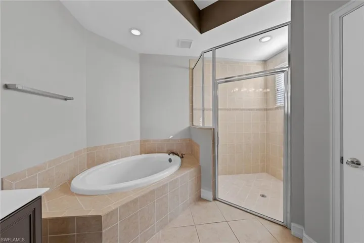 Full bathroom featuring a garden tub, tile patterned floors, a shower stall, vanity, and recessed lighting