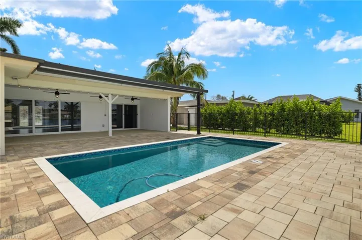 View of pool featuring a ceiling fan, a patio, and fence