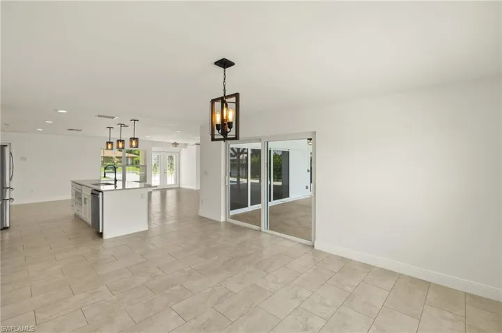 Unfurnished room featuring recessed lighting, a chandelier, baseboards, and a sink