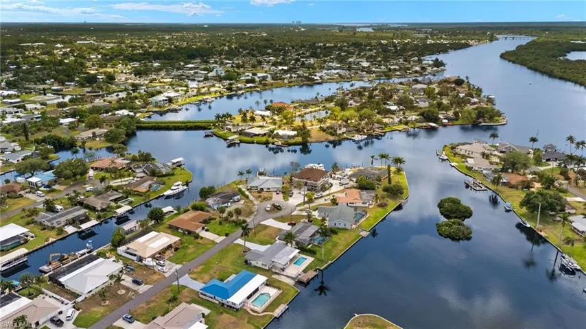 Aerial view of property and surrounding area with a large body of water and nearby suburban area