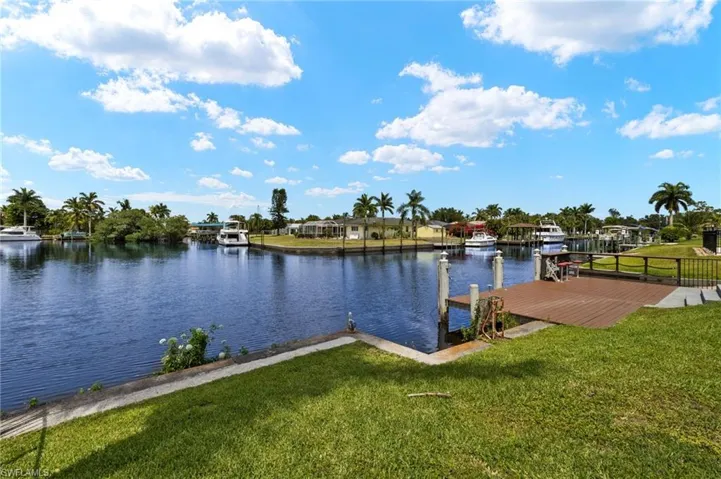 Dock area with a water view and a yard