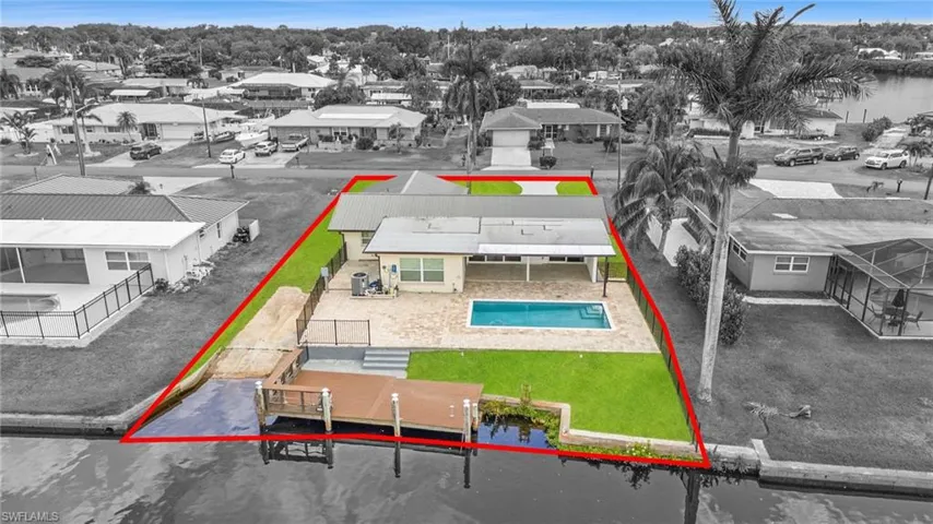 Virtually enhanced. Aerial perspective of suburban area with property boundaries highlighted, a pool, and a nearby body of water