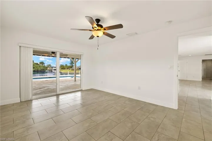 Spare room featuring a ceiling fan, baseboards, a smoke detector, and light tile patterned floors