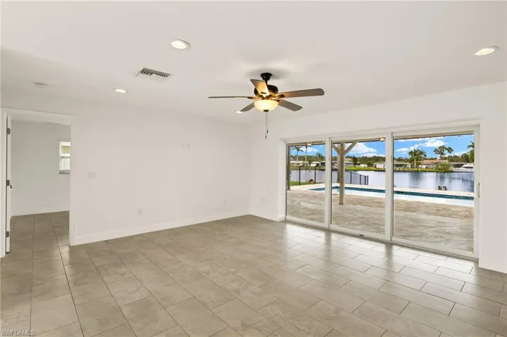 Unfurnished room with a ceiling fan, recessed lighting, baseboards, and a water view