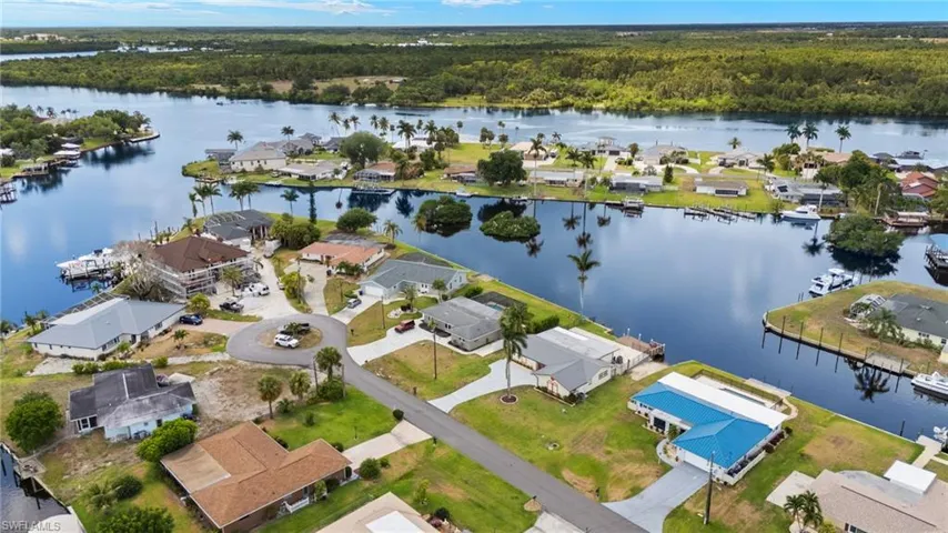 View of property location with a large body of water, a forest, and nearby suburban area