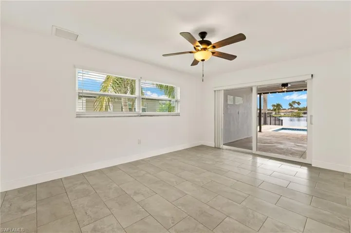 Unfurnished room with healthy amount of natural light, a ceiling fan, and baseboards