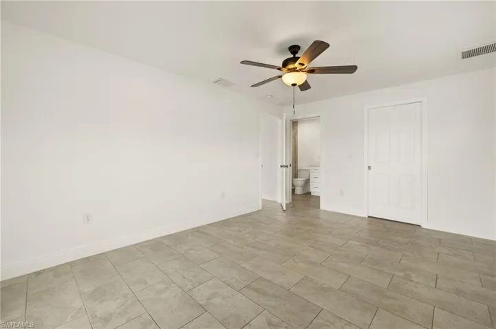 Unfurnished room with a ceiling fan and baseboards