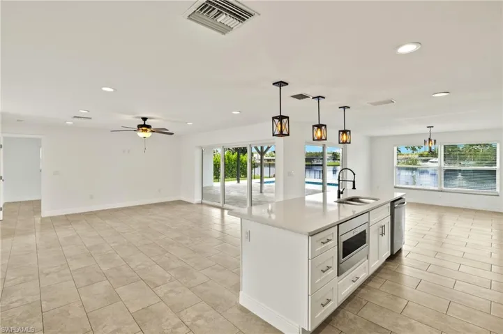 Kitchen with a sink, appliances with stainless steel finishes, recessed lighting, open floor plan, and light countertops