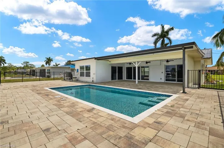 View of pool featuring ceiling fan, a patio, and fence