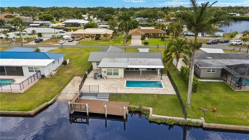 Aerial perspective of suburban area featuring a pool area and a large body of water