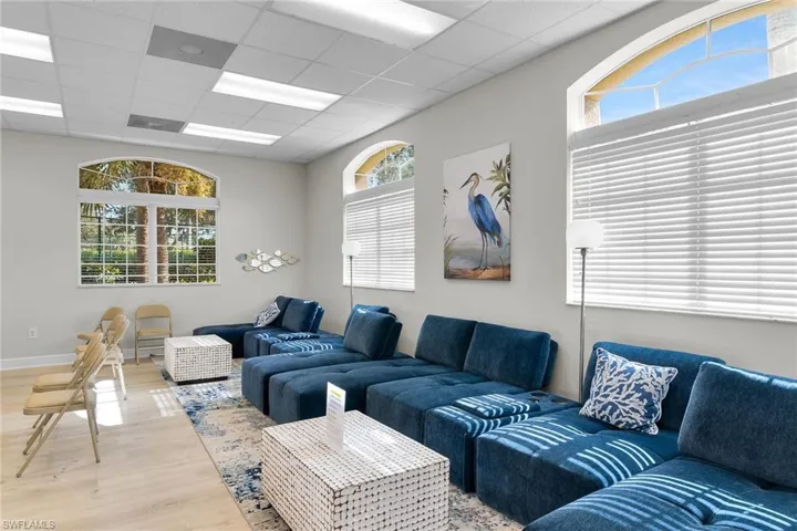 Living room with healthy amount of natural light, a paneled ceiling, and wood finished floors