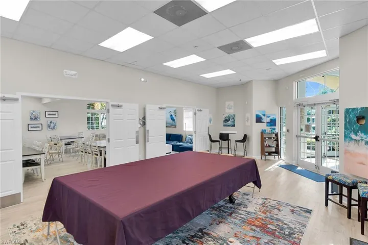 Recreation room featuring french doors, a paneled ceiling, billiards, and a high ceiling