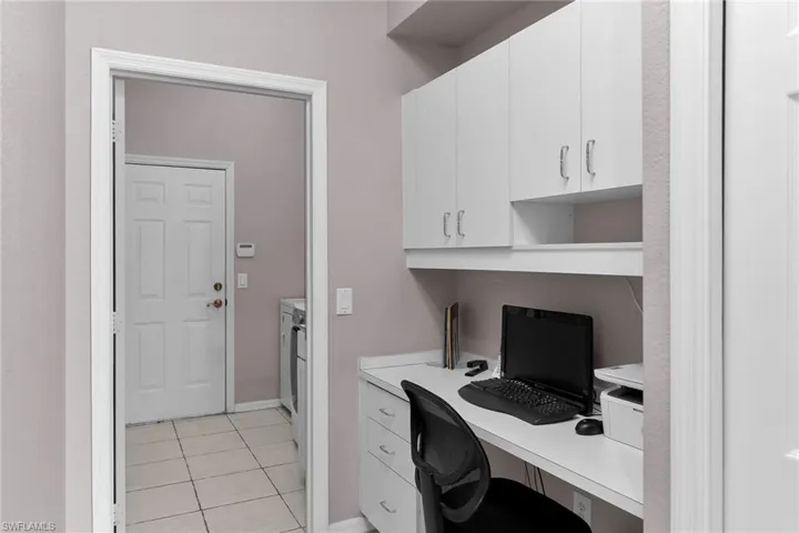 Home office with built in desk and light tile patterned floors