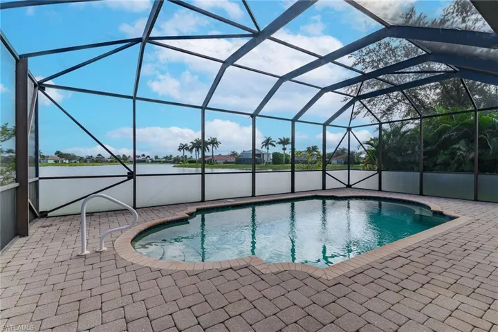 Outdoor pool with a lanai, a sunroom, a water view, and a patio