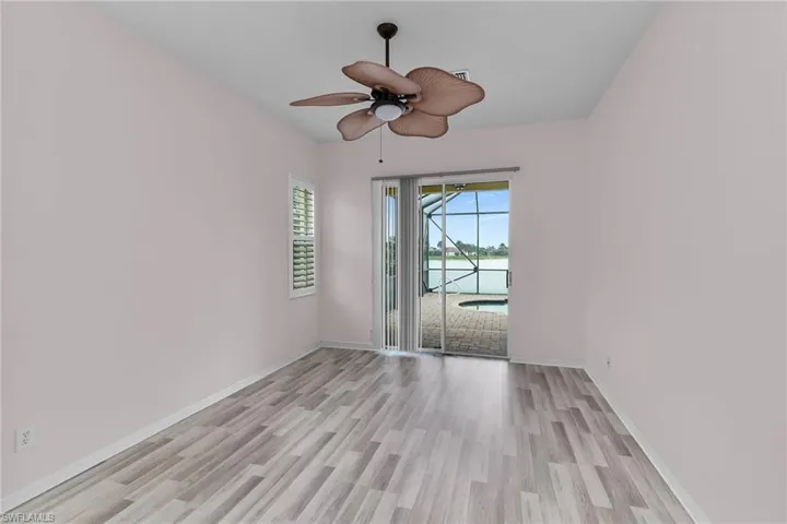 Unfurnished room with a water view, light wood finished floors, and ceiling fan