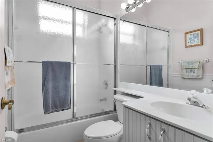 Bathroom featuring vanity and enclosed tub / shower combo