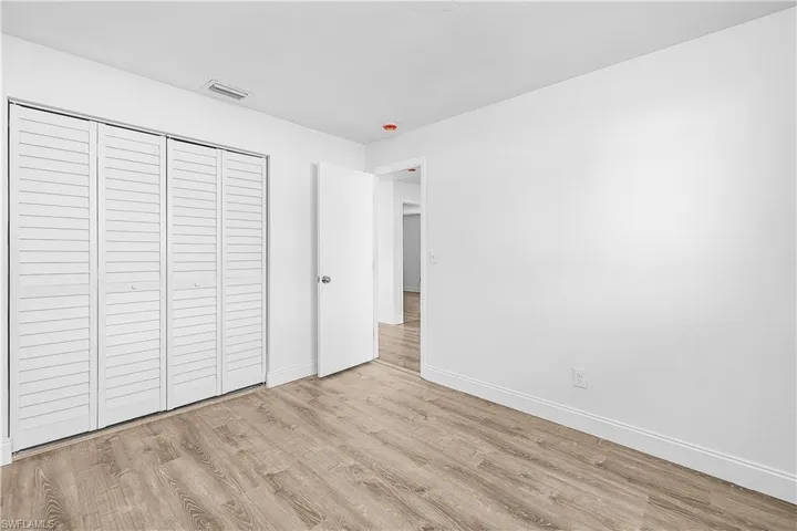 4012(R) Bedroom featuring new LVP light wood plank flooring and baseboards