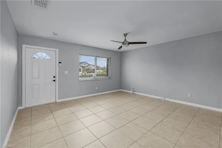 4014(L) Foyer/family room with a ceiling fan and light tile patterned flooring