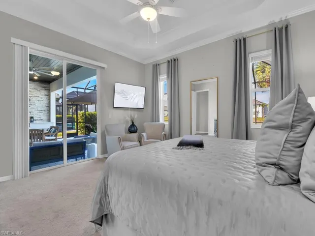 Ligh-filled primary bedroom opens to the lanai area through the sliding glass door.