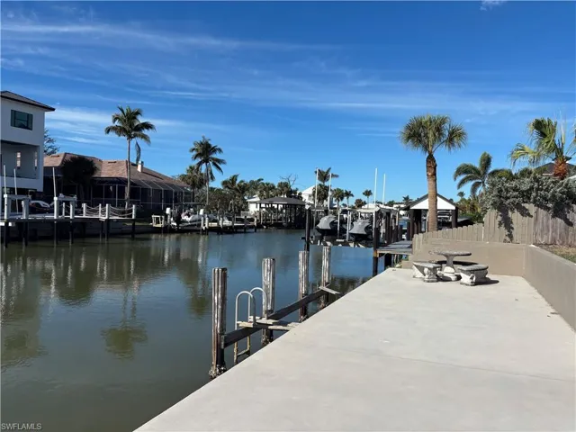Dock area with a water view and fence