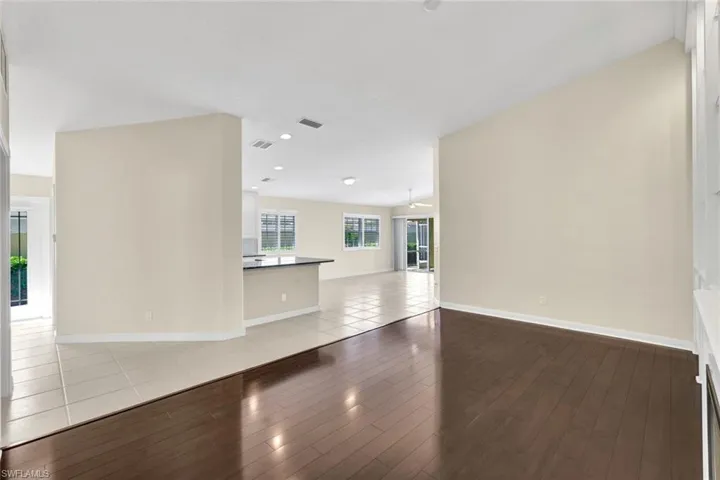 Vaulted ceilings, wood-finish flooring, recessed lighting, and a kitchen island with dark countertops