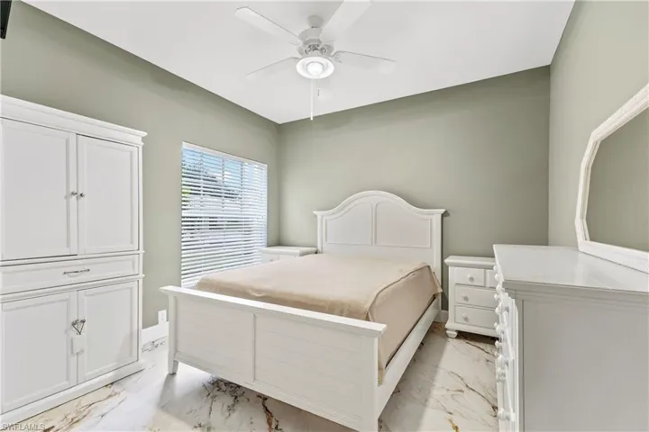 Bedroom with light marble finish flooring and ceiling fan