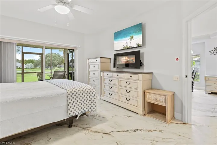Bedroom with access to outside, light marble finish floors, and ceiling fan