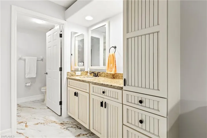 Full bathroom featuring light marble finish floors, vanity, and recessed lighting