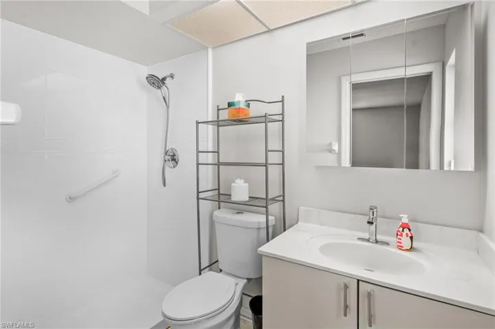 Full bath with tiled shower and vanity