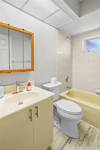Bathroom with vanity, wood finished floors, and shower / bath combination