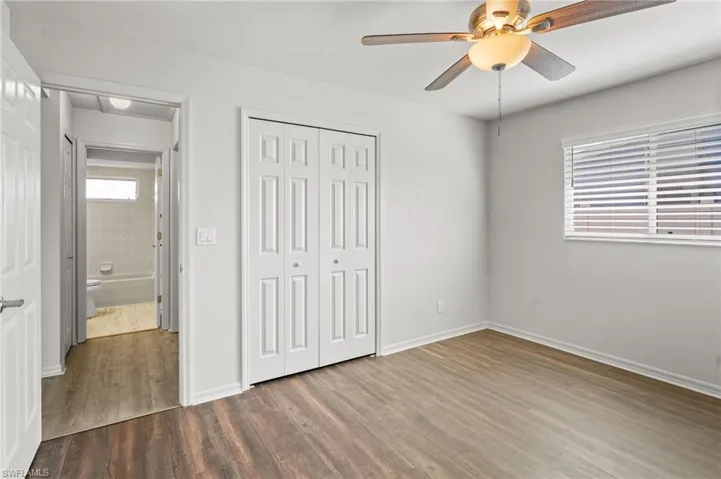Unfurnished bedroom featuring wood finished floors, a closet, and a ceiling fan