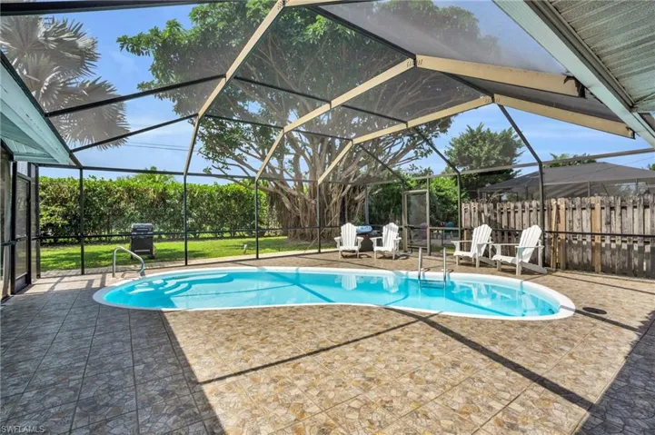 Large enclosed lanai with heated salt water pool and covered seating area - ideal for entertaining!