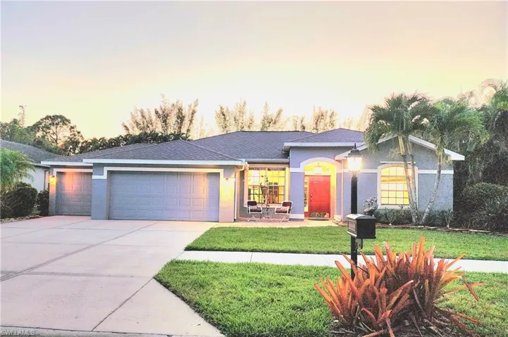 Ranch-style house featuring a garage and a lawn
