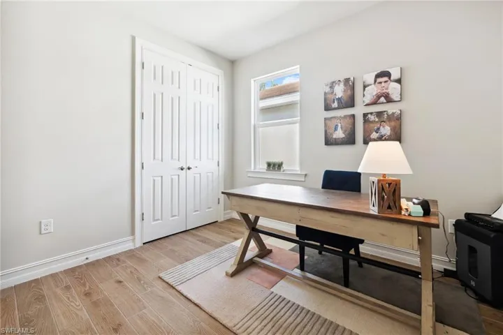 Office with light wood-type flooring and baseboards